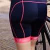 marineblauwe dames fietsbroek met bretels en roze naden